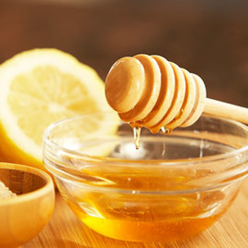 lemon and a bowl of honey with a honey stick