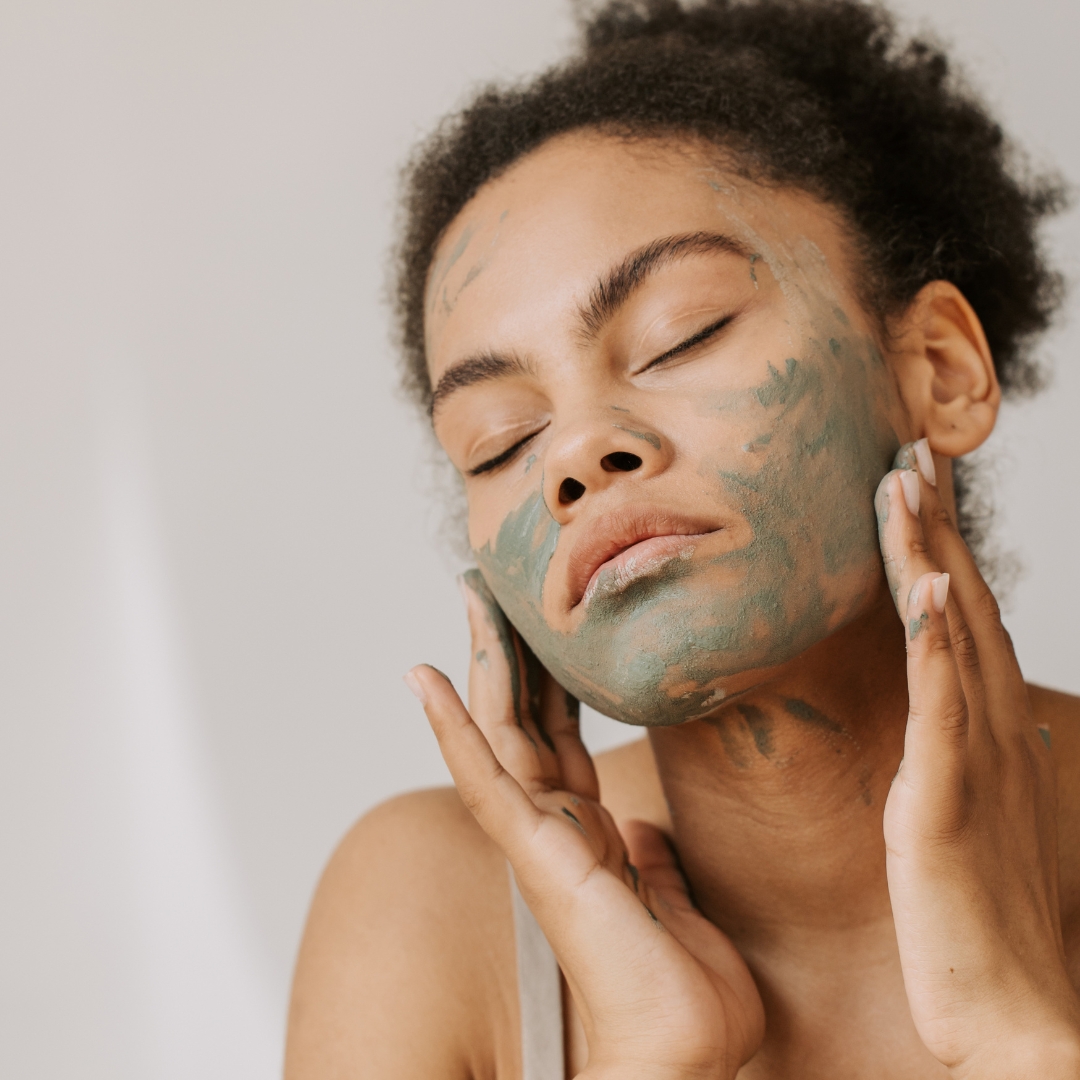 woman indulging in holistic skincare ritual by applying face mask