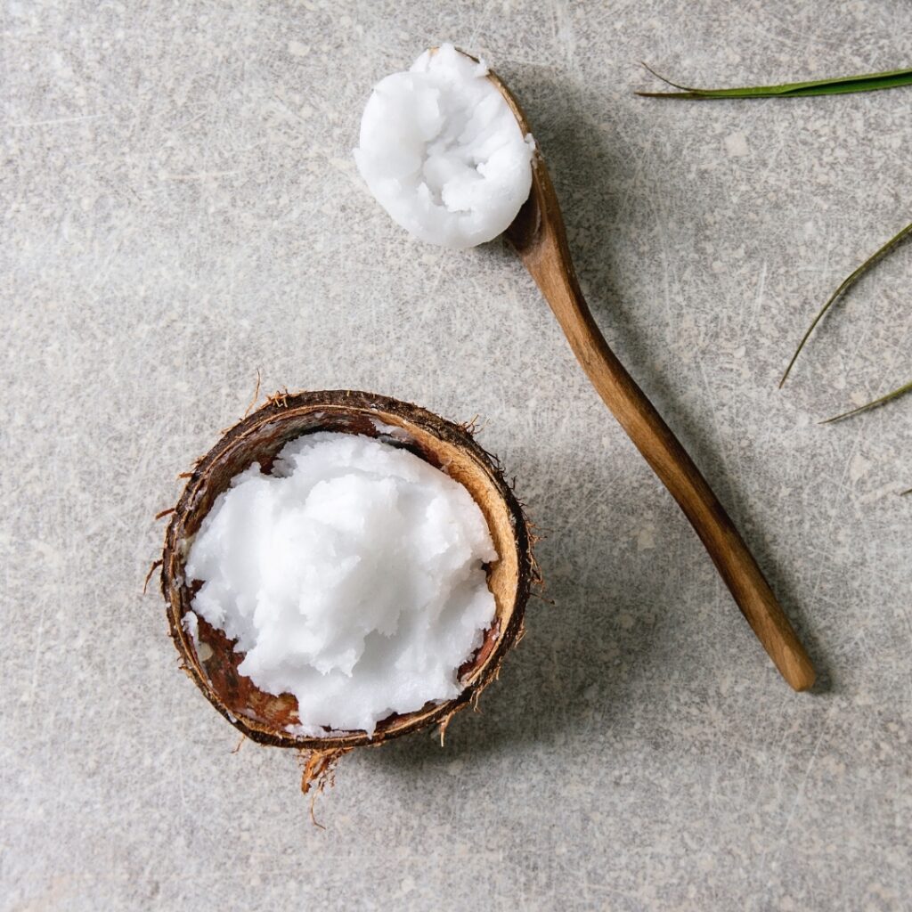 coconut oil in a bowl next to coconut oil in a spoon