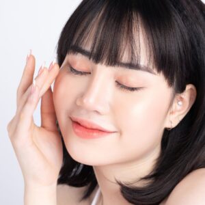 woman applying  carrot seed oil to her face