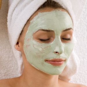 woman with coconut milk and avocado face mask on face