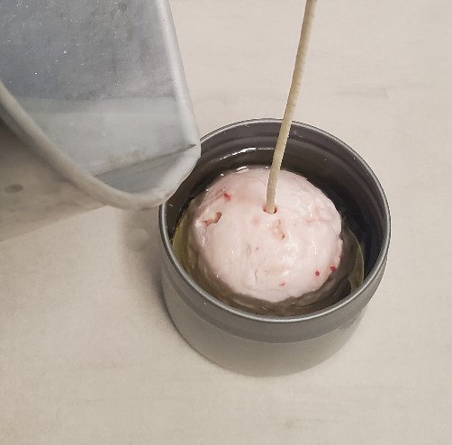 pouring wax over ice cream candle scoop