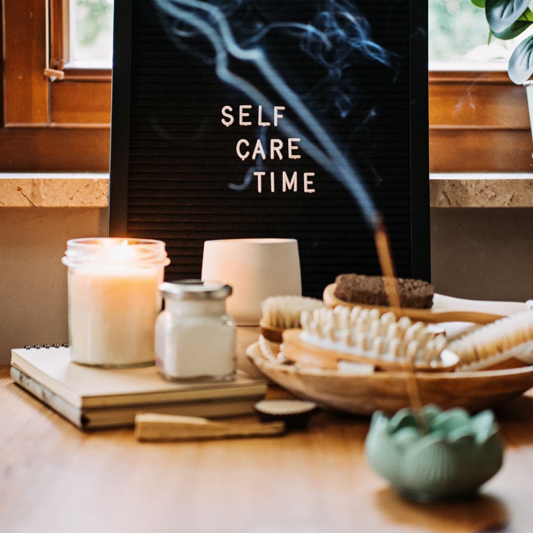 candles and burning incense in front of a sign that says self care time