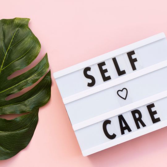 self care sign with a heart next to a plant leaf