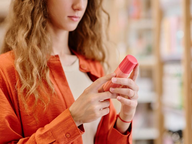 woman reading the label of a conventional skincare product
