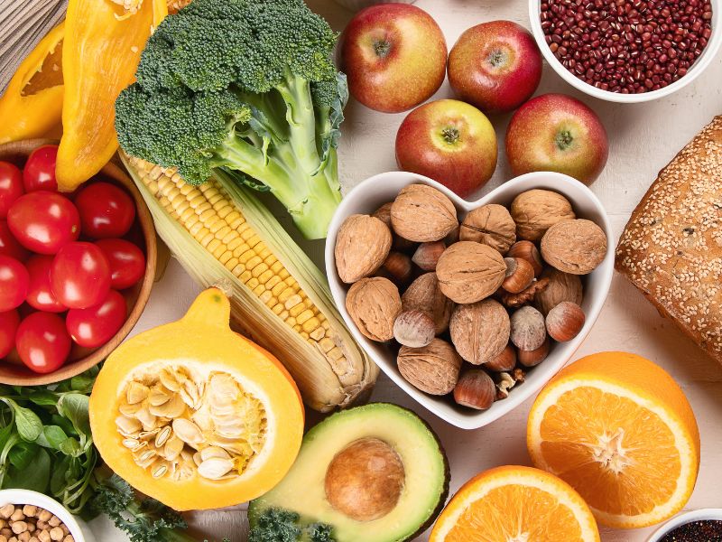 A display of colorful vegetables, fruit and nuts representing Pillar 4 of the of the  7 pillars of holistic skincare, Whole Food Diet.