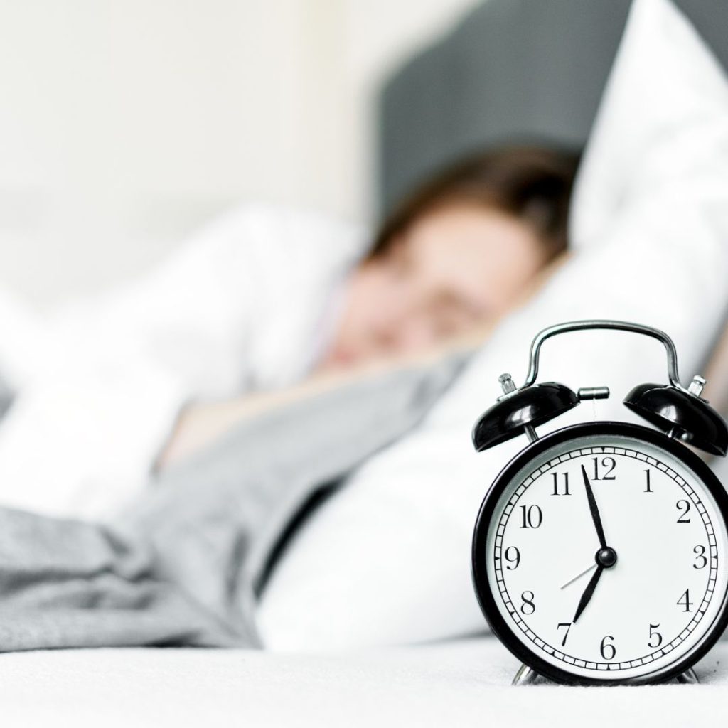 woman sleeping with an alarm clock facing forward